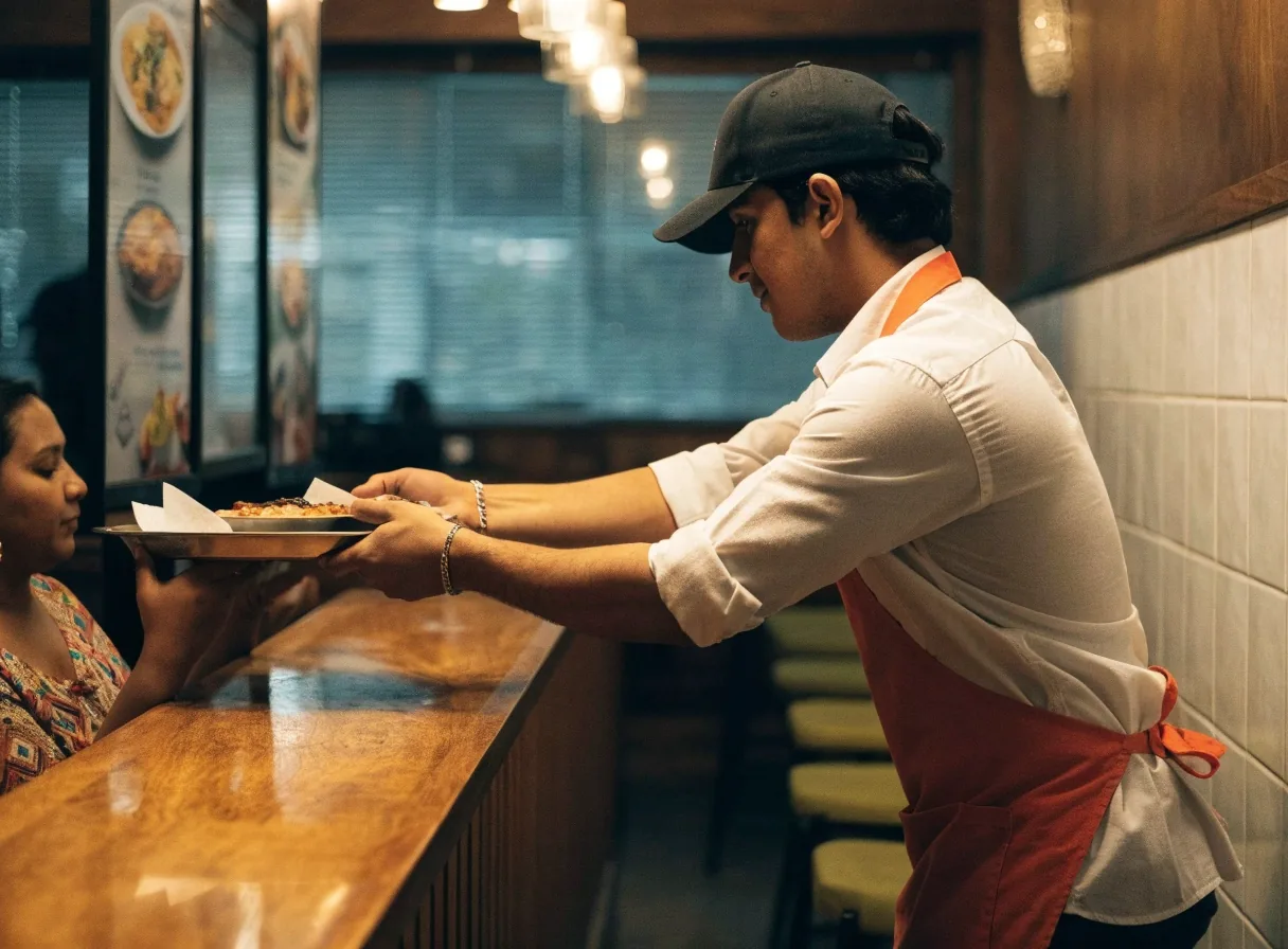 Guest receiving a tray at a Mexican grill counter